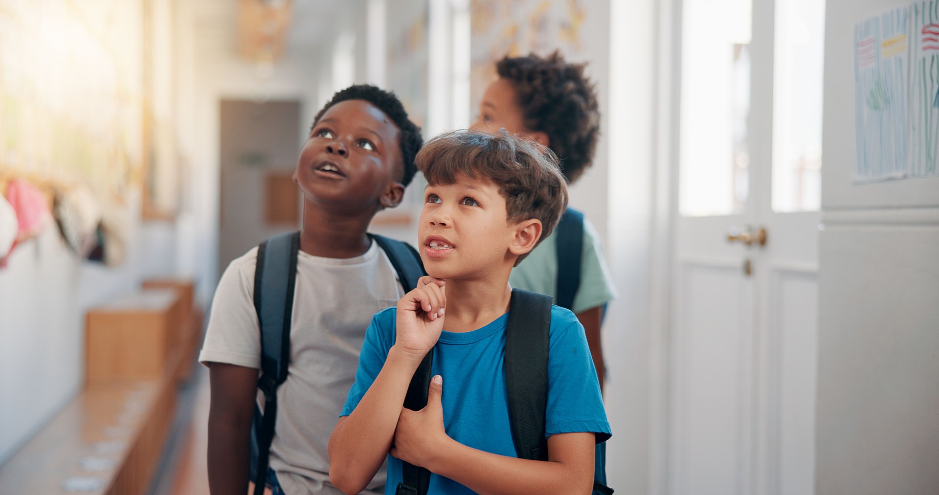 Children, friends and hallway at school for education, learning and idea at recess. Boys, classmates and students together for development, knowledge and thinking in elementary with creative art