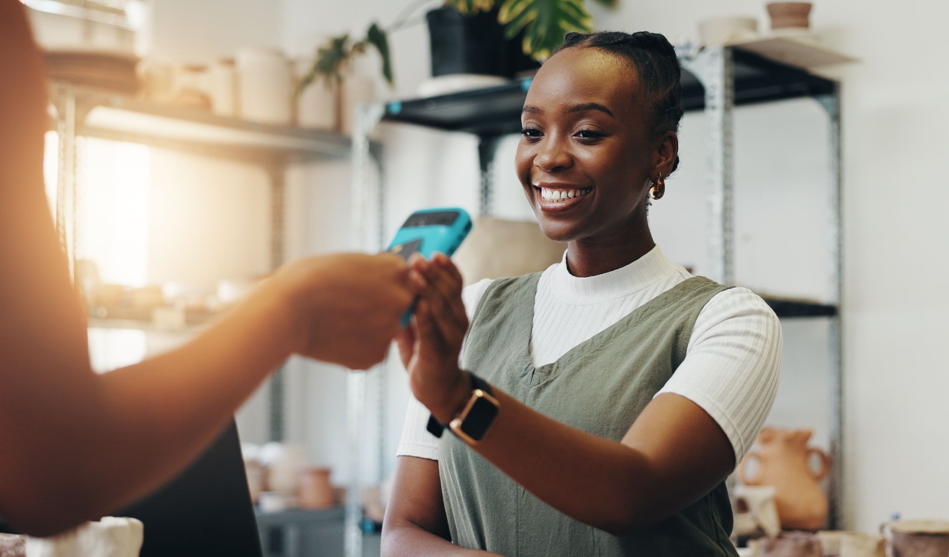 Happy woman, customer and pottery purchase with pos machine for electronic transaction or wireless payment. Female person, employee or smile with credit card tap for buy or shopping at ceramic store