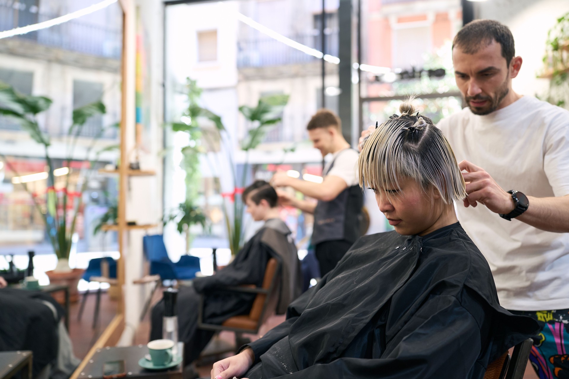 Hairdresser styling customer's hair in salon